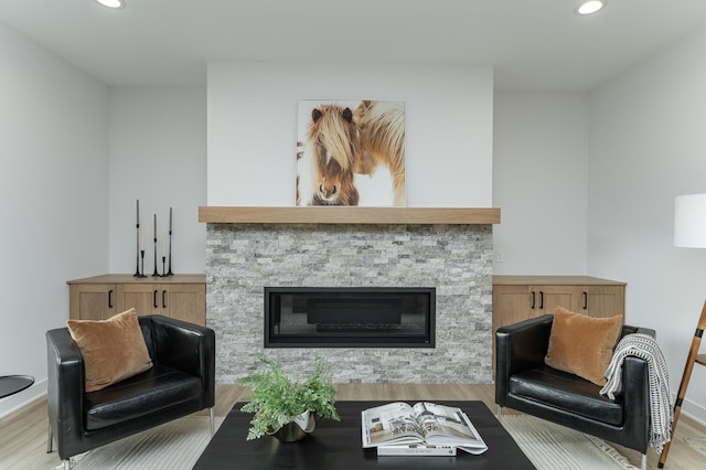 living room with recessed lighting, a fireplace, baseboards, and wood finished floors