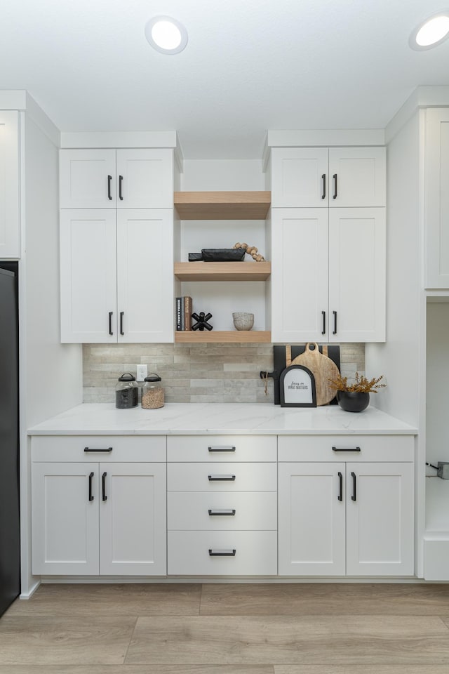 bar with fridge, light wood-style flooring, decorative backsplash, and recessed lighting