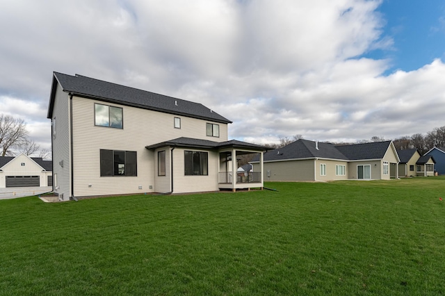 back of property with a lawn and an outdoor structure