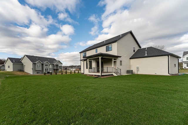 rear view of property featuring central AC and a yard