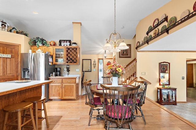 dining room featuring lofted ceiling, light hardwood / wood-style flooring, and a chandelier