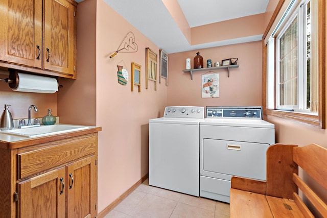 laundry room featuring light tile patterned floors, cabinets, sink, and separate washer and dryer