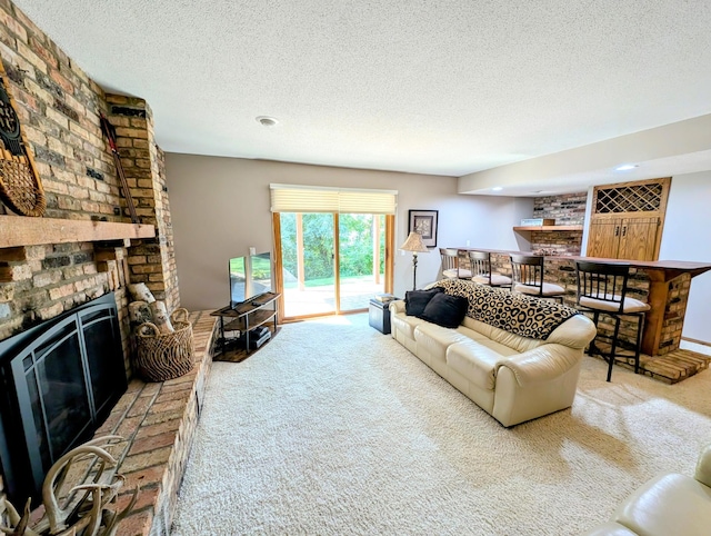 living room featuring light carpet, a brick fireplace, indoor bar, and a textured ceiling