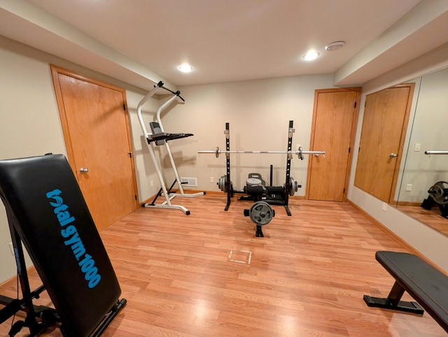 workout area with light hardwood / wood-style flooring