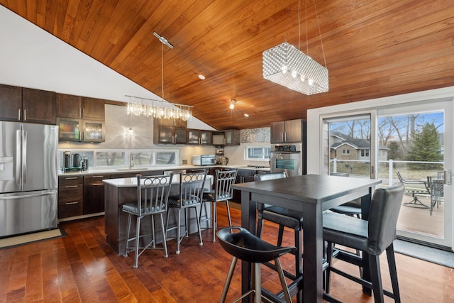 kitchen featuring appliances with stainless steel finishes, dark brown cabinetry, wooden ceiling, a center island, and dark hardwood / wood-style floors