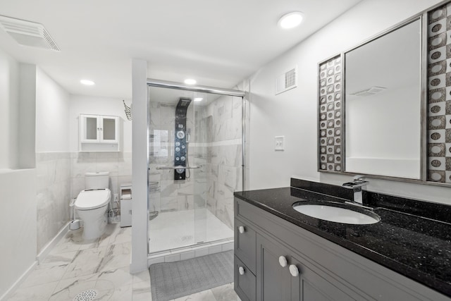 bathroom with vanity, toilet, an enclosed shower, and tile walls