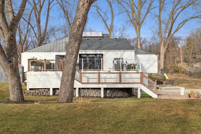 back of house featuring a lawn, a patio area, and a wooden deck