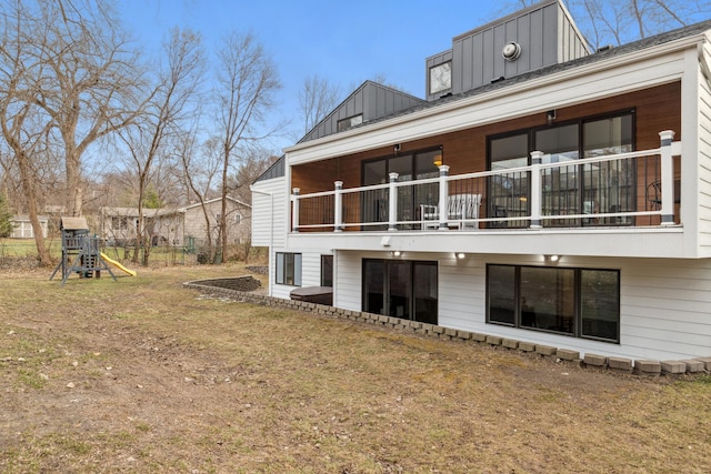 rear view of property with a playground