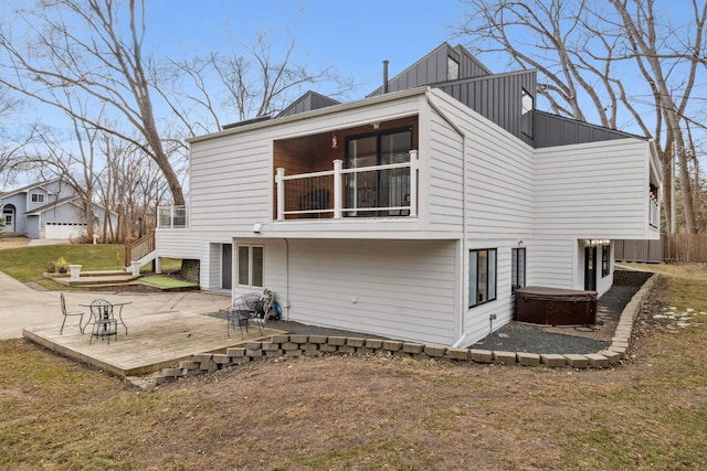 rear view of property with a balcony and a deck