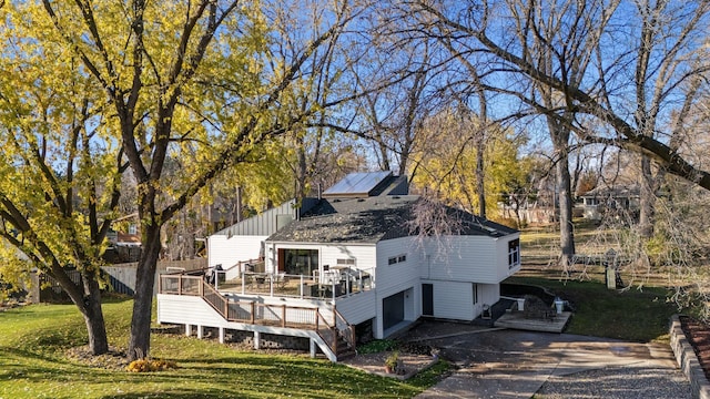 exterior space with a yard, a garage, and a wooden deck