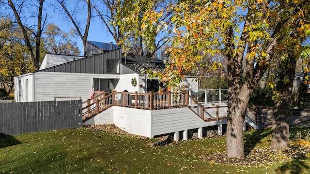 rear view of property with a deck and a lawn