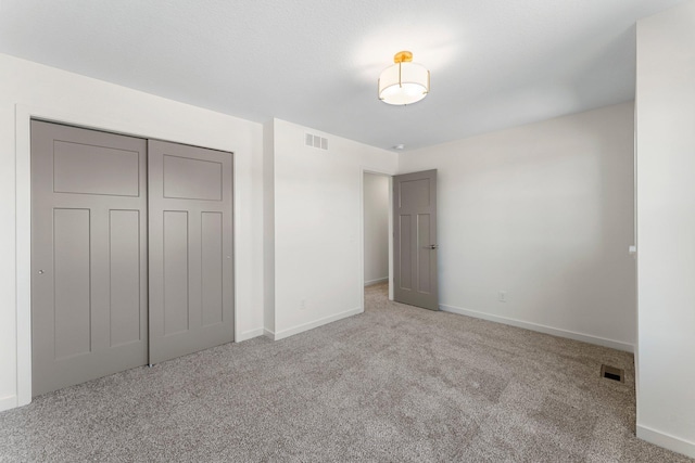 unfurnished bedroom featuring light carpet and a closet