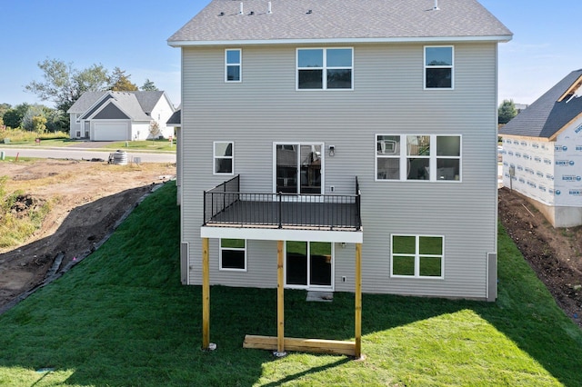 back of house featuring a lawn and a balcony