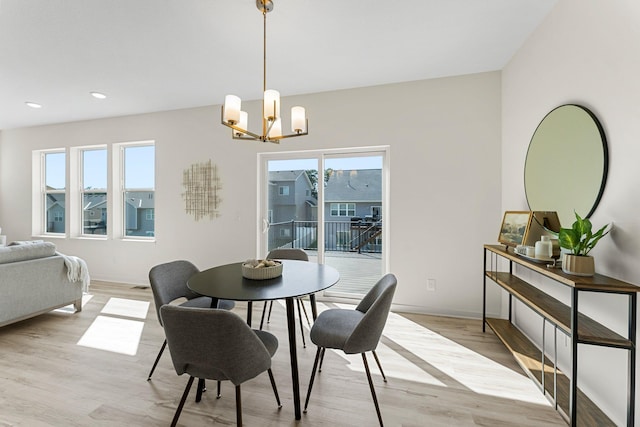 dining room with light hardwood / wood-style floors and a notable chandelier