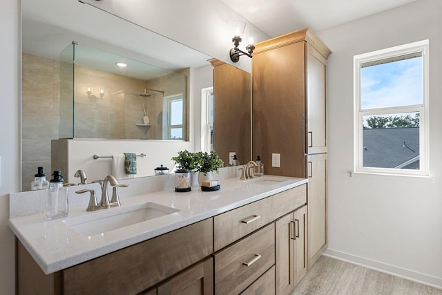 bathroom featuring hardwood / wood-style flooring, vanity, and tiled shower