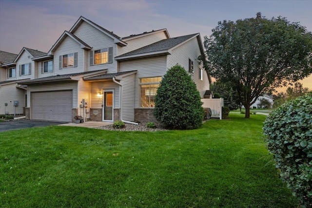 view of front of house featuring a front lawn, an attached garage, and driveway