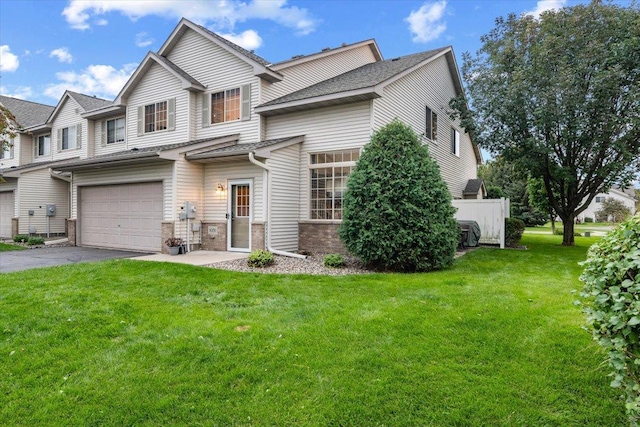 view of front of house featuring aphalt driveway, fence, a front yard, an attached garage, and brick siding