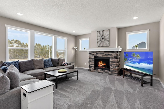 living area with a fireplace, a textured ceiling, baseboards, and carpet floors