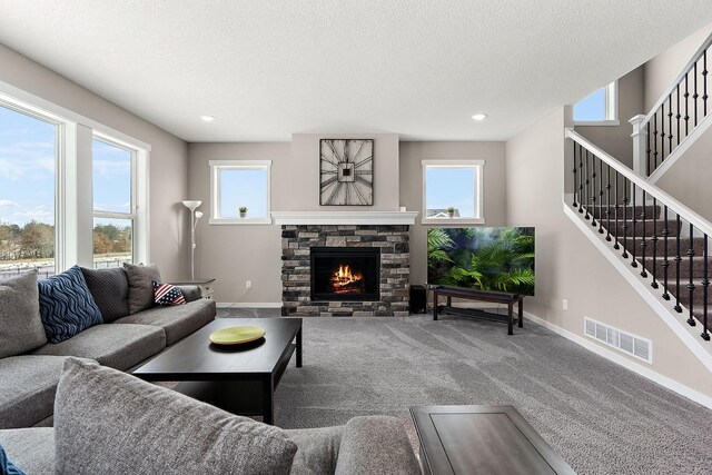 living room featuring stairs, carpet flooring, a healthy amount of sunlight, and visible vents