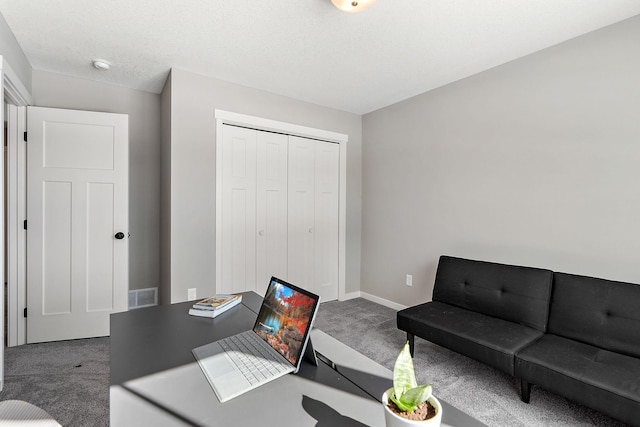 carpeted home office with baseboards, visible vents, and a textured ceiling