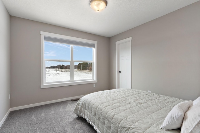 carpeted bedroom with visible vents, baseboards, and a textured ceiling