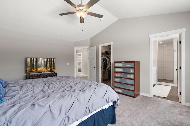 bedroom featuring connected bathroom, a walk in closet, vaulted ceiling, carpet floors, and a closet