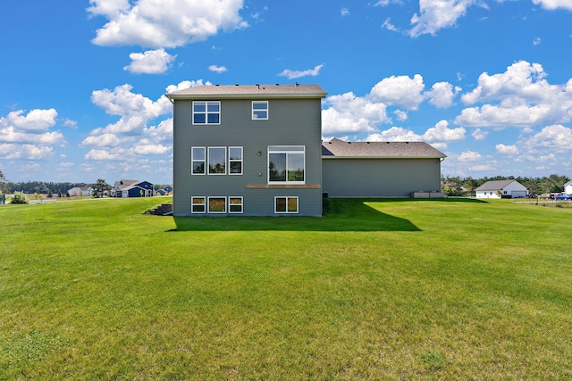 rear view of property featuring a lawn