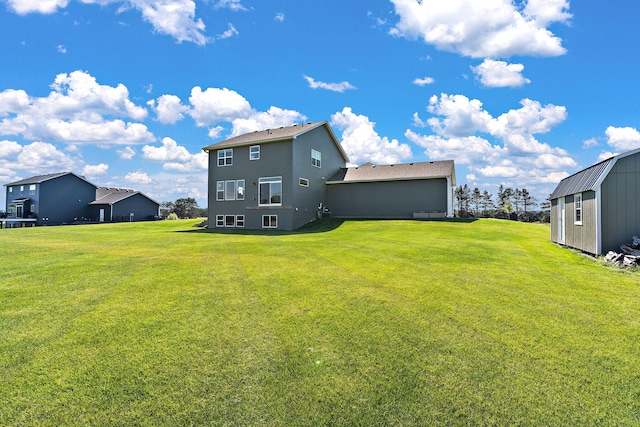 rear view of house with an outbuilding and a lawn