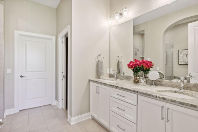 bathroom with a shower, tile patterned floors, and vanity