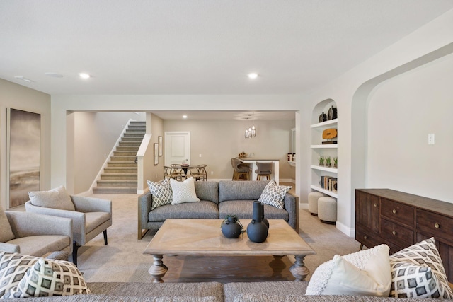 living room with built in shelves and light carpet