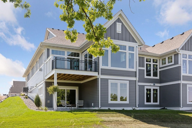 rear view of property with a balcony and a yard