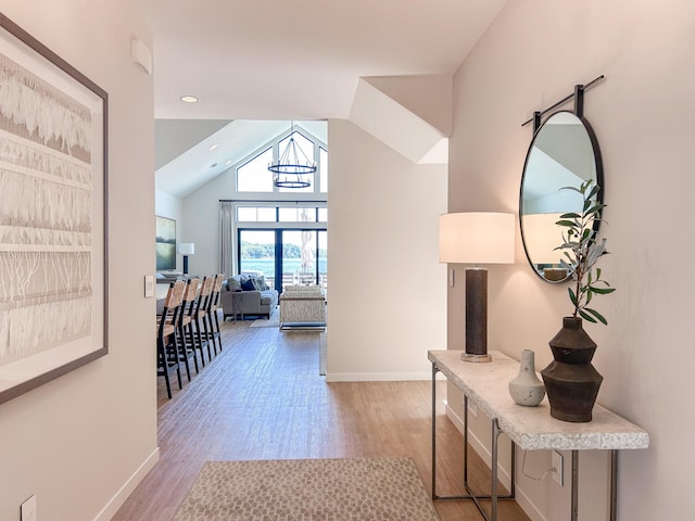 interior space featuring lofted ceiling and light hardwood / wood-style flooring