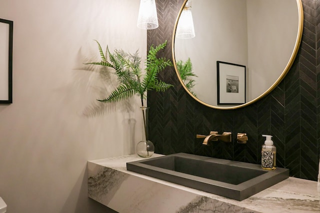 bathroom with sink and decorative backsplash