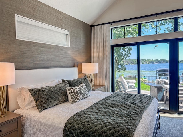 bedroom featuring vaulted ceiling, a water view, and access to outside