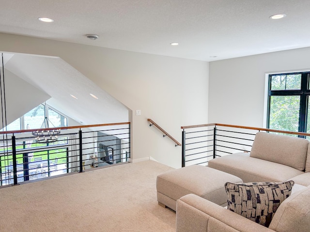 living room featuring a textured ceiling, a wealth of natural light, and carpet flooring