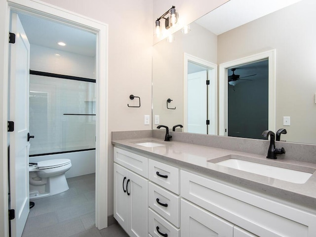 full bathroom with vanity, enclosed tub / shower combo, and toilet