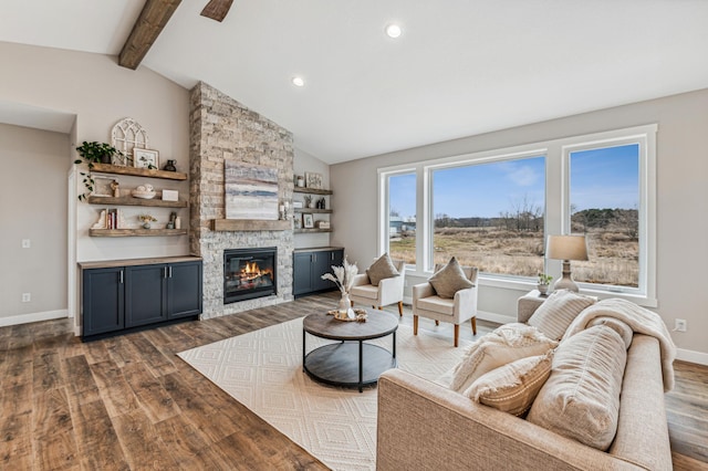 living room with hardwood / wood-style floors, lofted ceiling with beams, and a stone fireplace