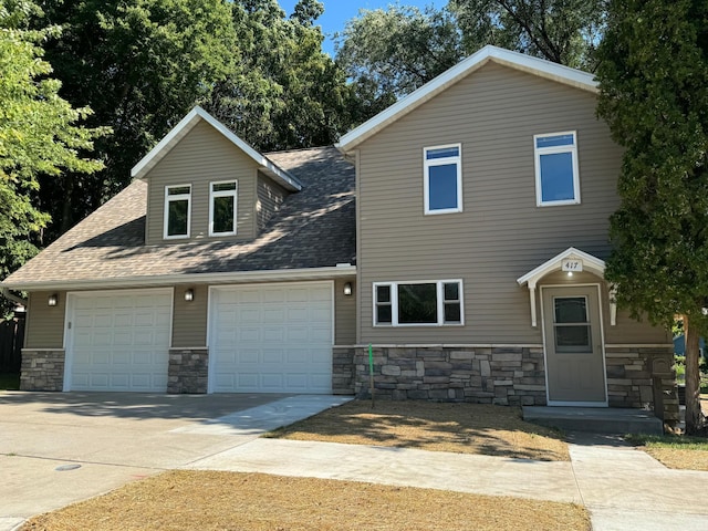 417 Pine St, Saint Peter, MN 56082 - view of front facade featuring concrete driveway, an attached garage, roof with shingles, and stone siding