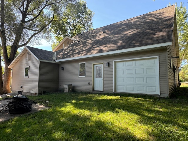 rear view of house with a yard and a garage