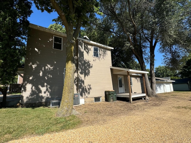 back of house featuring a lawn and central AC