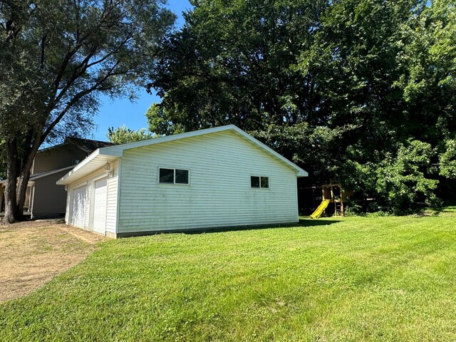 417 Pine St, Saint Peter, MN 56082 - view of side of home with a garage, a yard, a playground, and an outdoor structure