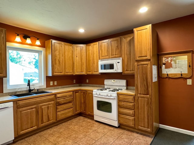 kitchen with white appliances, light tile patterned floors, and sink