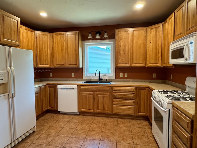 kitchen with sink, light tile patterned floors, and white appliances