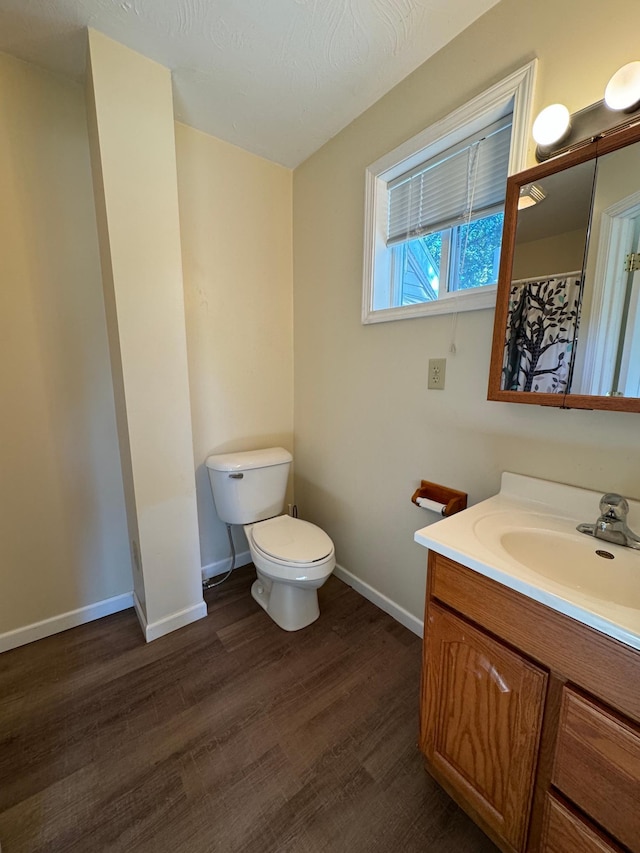 bathroom featuring vanity, toilet, hardwood / wood-style flooring, and a textured ceiling