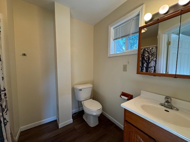 bathroom with wood-type flooring, toilet, walk in shower, and vanity