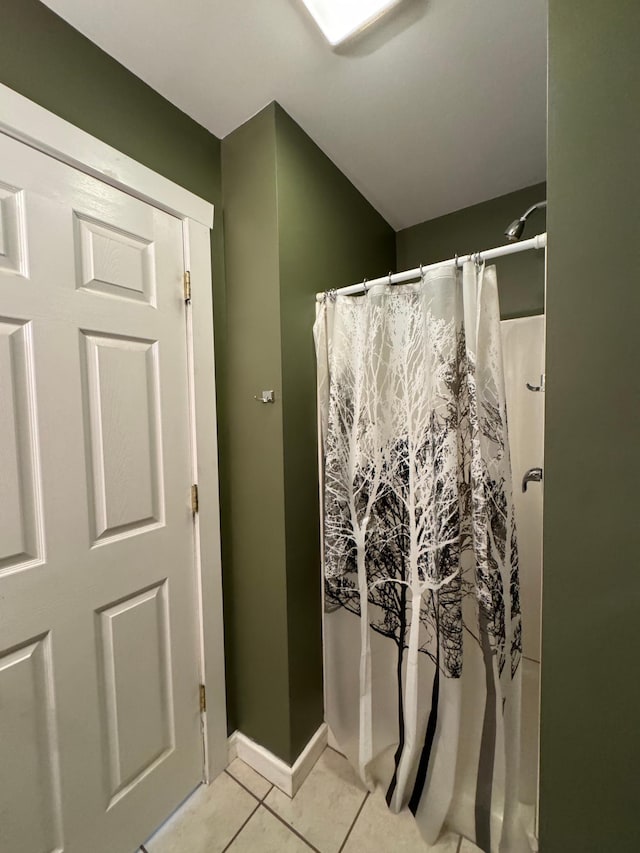 bathroom with a shower with shower curtain and tile patterned flooring