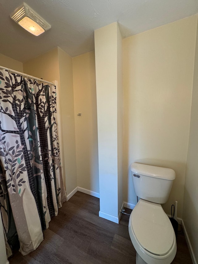 bathroom featuring walk in shower, toilet, and hardwood / wood-style flooring