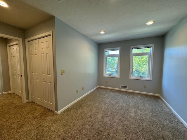 carpeted spare room with a textured ceiling