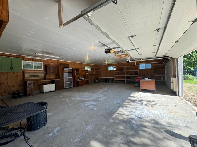 garage with a garage door opener and wood walls