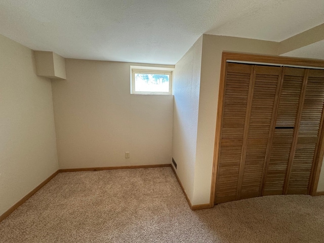 unfurnished bedroom featuring light carpet, a textured ceiling, and a closet